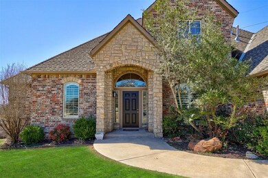 View of front facade with stone siding, brick siding, a front yard, and a shingled roof