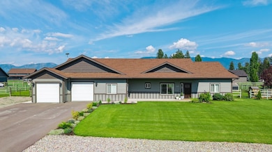 Single story home with a mountain view, an attached garage, asphalt driveway, a porch, and a shingled roof