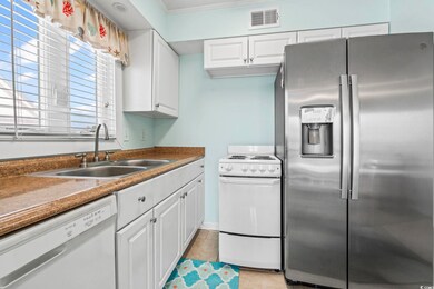 Kitchen with white appliances, white cabinets, crown molding, and light tile patterned floors