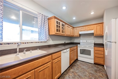 Kitchen featuring under cabinet range hood, dark c