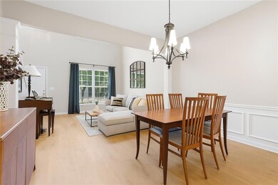 Dining space with a chandelier, light wood-type flooring, and wainscoting