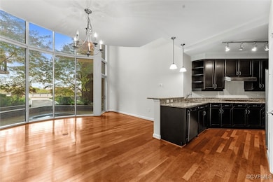 Kitchen with dark cabinetry, dishwasher, open shel