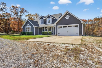 View of front of home featuring covered porch, driveway, a front lawn, and an attached garage