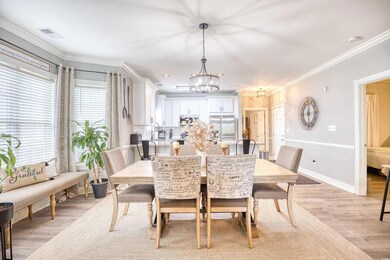 Dining room with a notable chandelier, light hardw