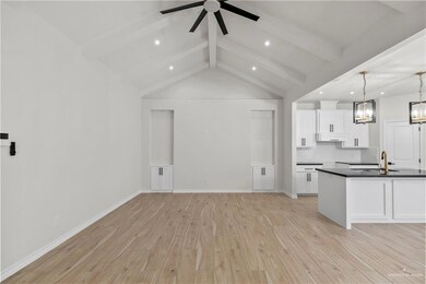 Kitchen with white cabinets, light hardwood / wood-style floors, and decorative light fixtures