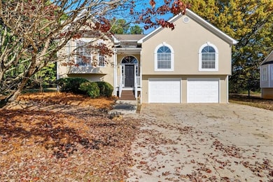 Bi-level home featuring stucco siding, concrete driveway, and an attached garage