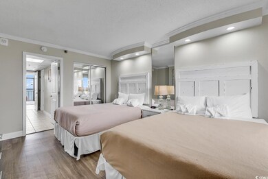 Bedroom featuring ornamental molding, wood finished floors, a textured ceiling, baseboards, and recessed lighting