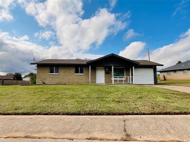 Single story home with a garage and a front lawn