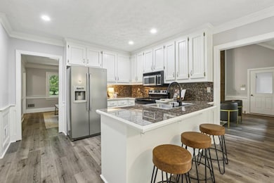 The Eat-In Kitchen features White Cabinets to the Ceiling, Stainless Steel Appliances, Granite Countertops, and a Breakfast Bar.