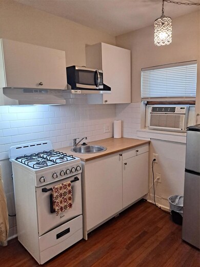 Kitchen with range, exhaust hood, a sink, fridge,