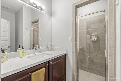 Bathroom featuring walk in shower and large vanity