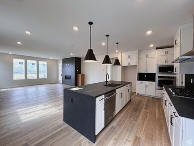 Kitchen featuring chef's kitchen, pendant lighting, white cabinetry and Kitchen Aid appliances.