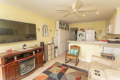 Living area with stacked washer / dryer, a ceiling fan, crown molding, light tile patterned flooring, and recessed lighting