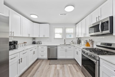 Kitchen with light wood-style flooring, backsplash