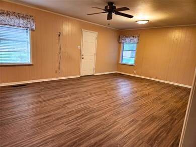 Unfurnished room with ceiling fan, a wealth of natural light, dark wood-type flooring, and wood walls