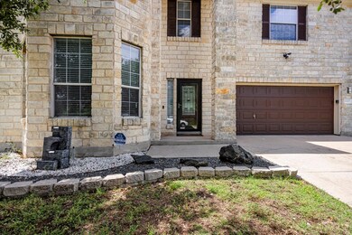 Property entrance with stone siding, concrete dri