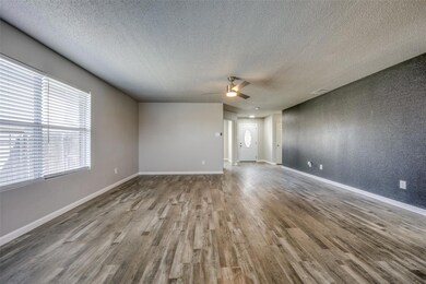 Unfurnished room with ceiling fan, hardwood / wood-style floors, and a textured ceiling