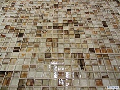 Mosaic glass floor in powder room.