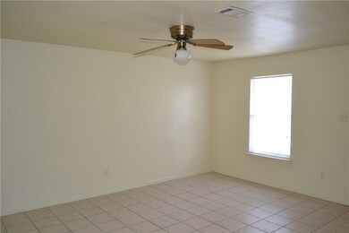 Empty room featuring a ceiling fan and baseboards