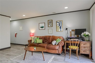 Living room featuring ornamental molding, light w