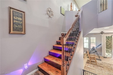 Stairs featuring a ceiling fan, baseboards, and ca