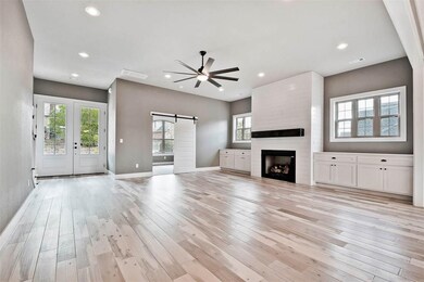 Stunning floor to ceiling shiplap fireplace flanked by built-in storage. Office boasts barn door entry!