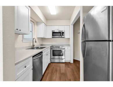 Kitchen featuring dark wood-type flooring, a sink