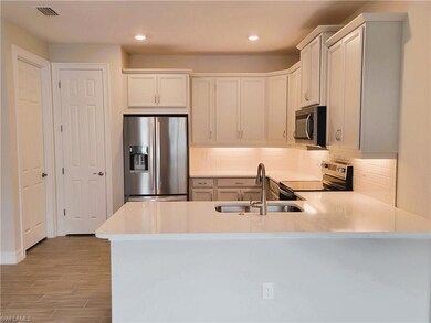 Kitchen with a peninsula, visible vents, a sink, s