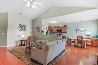Living room featuring light wood finished floors, ceiling fan, and high vaulted ceiling
