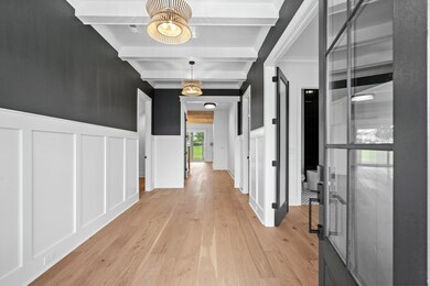 Hall featuring beamed ceiling, light hardwood / wo