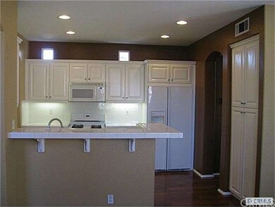 Sparkling clean kitchen opens to living room.