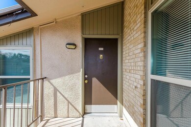 View of exterior entry with brick siding, a balcon