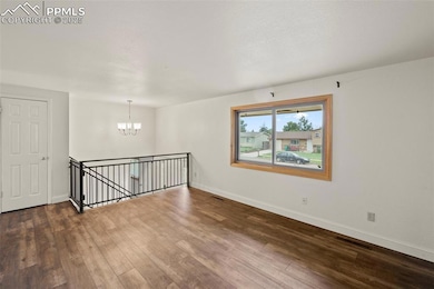 Spare room with a chandelier and hardwood / wood-style floors