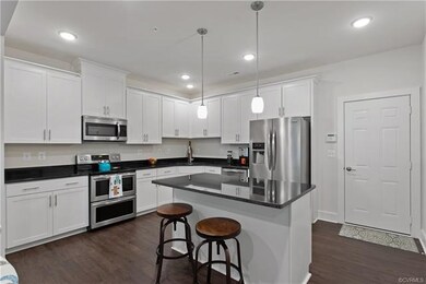 The kitchen island features a cozy breakfast bar f