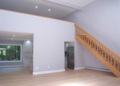 Unfurnished living room with baseboard heating, wood finished floors, stairway, recessed lighting, and a high ceiling