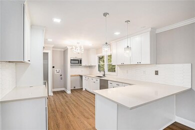Kitchen featuring kitchen peninsula, white cabinet