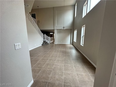 Unfurnished living room with a towering ceiling, s