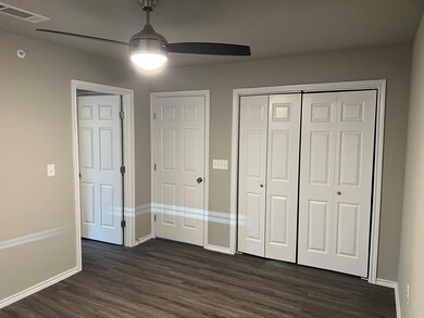 Unfurnished bedroom with dark wood-type flooring a