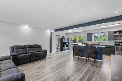 Living area with light wood-type flooring and a textured ceiling