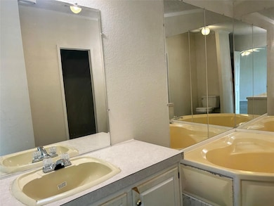 Full bathroom with a textured wall and vanity