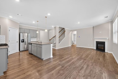 Kitchen featuring gray cabinetry, decorative backsplash, recessed lighting, appliances with stainless steel finishes, and wood finished floors