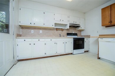 Kitchen featuring light floors, electric stove, light countertops, and dishwasher
