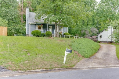 View of front of house featuring a porch, a chimney, and driveway