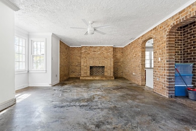 Unfurnished living room with ceiling fan, brick wa