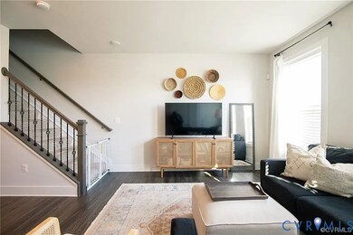 Living room featuring dark wood-type flooring and stairs