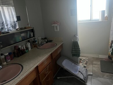Full bath featuring double vanity, a shower with shower curtain, and light tile patterned floors