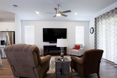 Living room featuring a ceiling fan, wood finishe