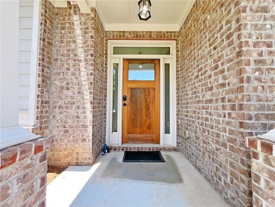 View of exterior entry featuring brick siding