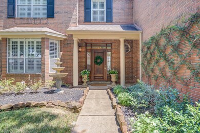 Beautiful brick entry way with pillars and plush l