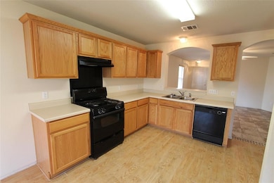 Kitchen featuring arched walkways, black applianc